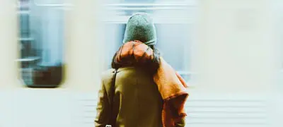 wartende Frau am Bahnhof mit vorbeifahrendem Zug